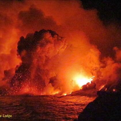 燃える火山の溶岩流が海へと流れ落ちる